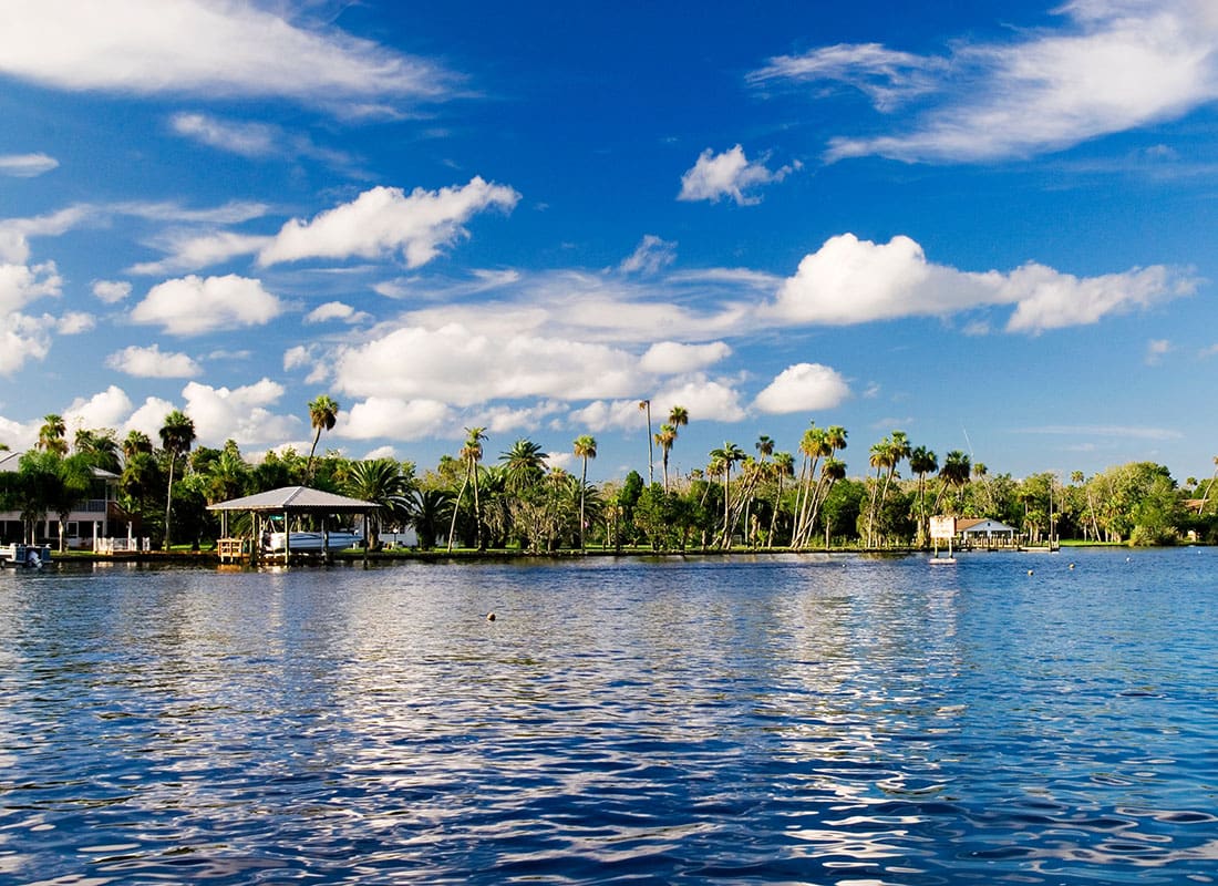 Homossasa Springs, FL - River Surrounded by Palm Trees and Homes on a Sunny Day in Homosassa Springs Florida